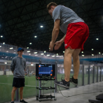 Bryce stands while athlete is in the air after jumping