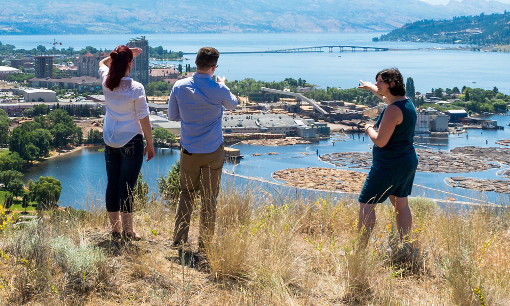 Undergraduate students engage with faculty atop of Know Mountain in Kelowna, British Columbia, Canada.